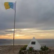 Bandera Nacional junto al monolito de Juan Antonio Betancort