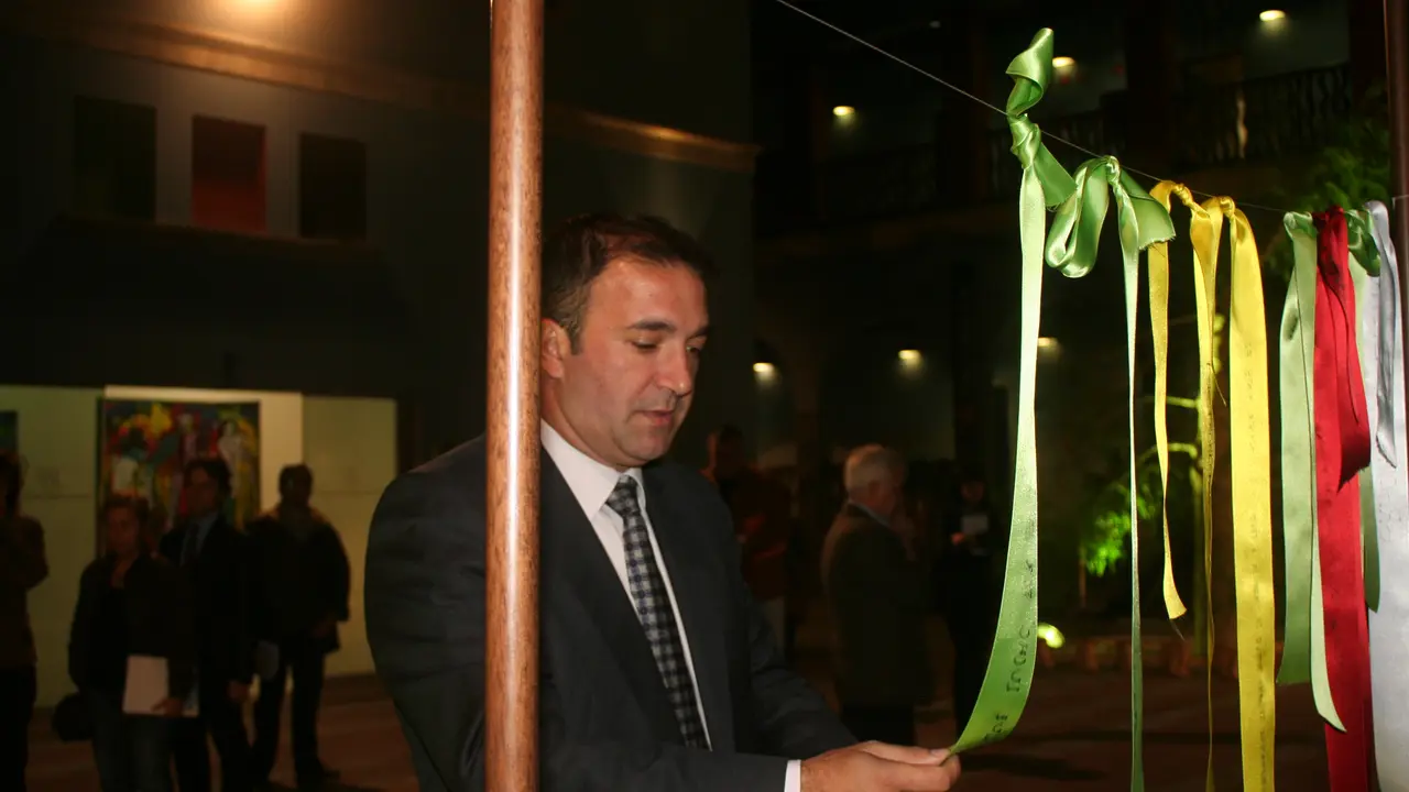 JL García Morera colgando cinta sobre Madiba