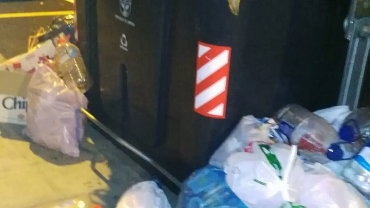 Basura amontonada fuera de los contenedores