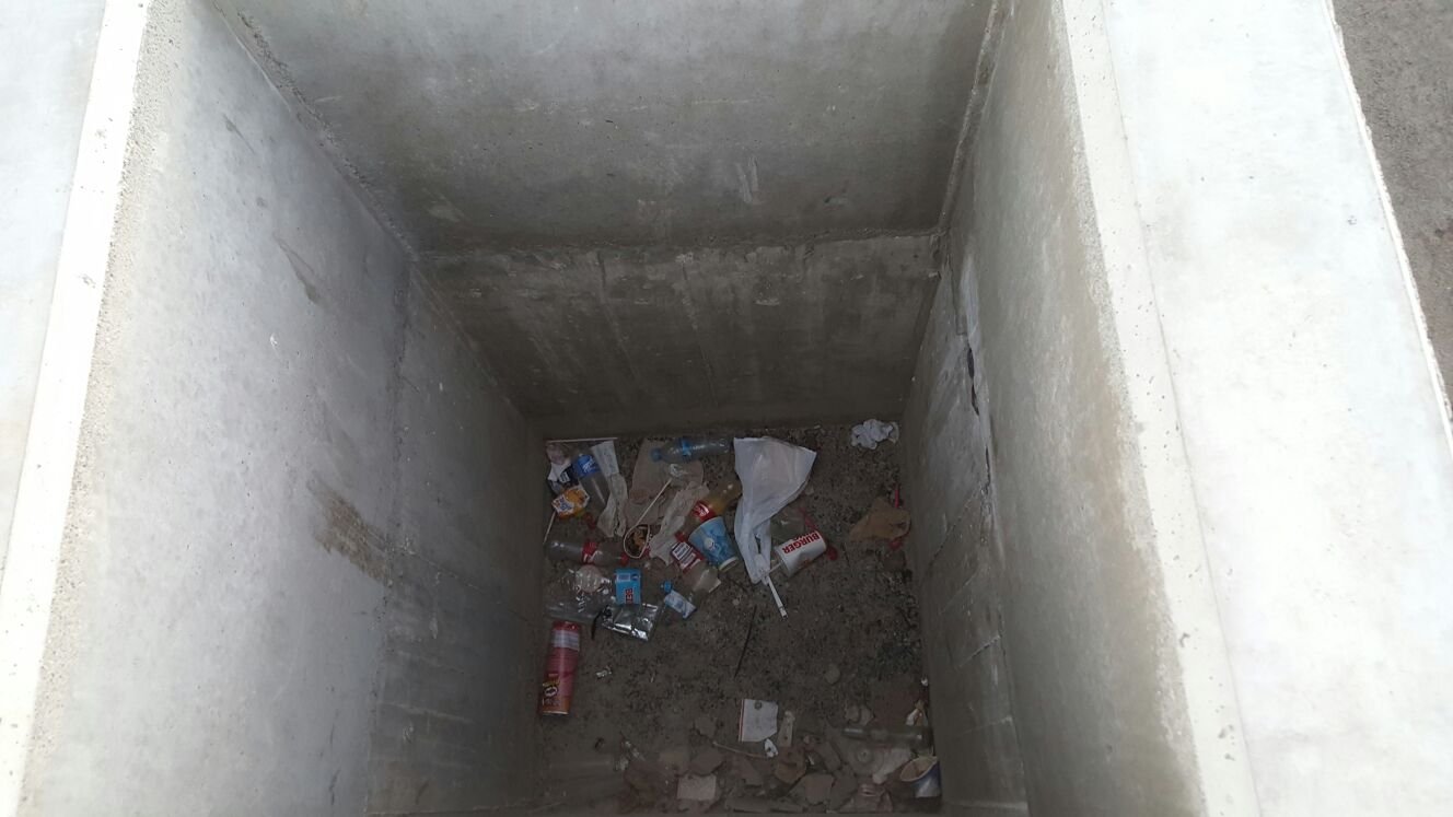 Interior de la arqueta llena de basura