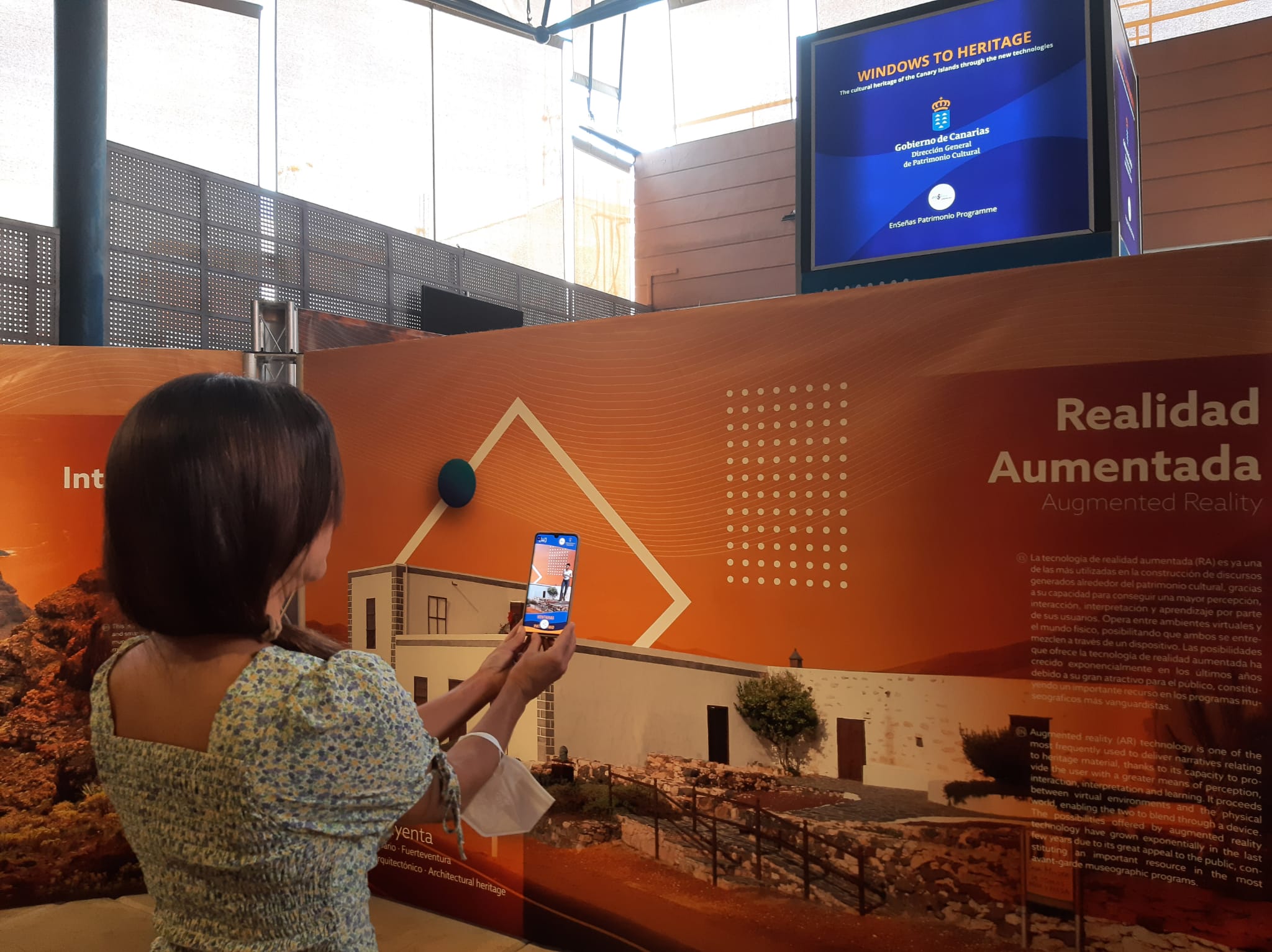 Una persona opera con su movil en la muestra Ventanas al Patrimonio